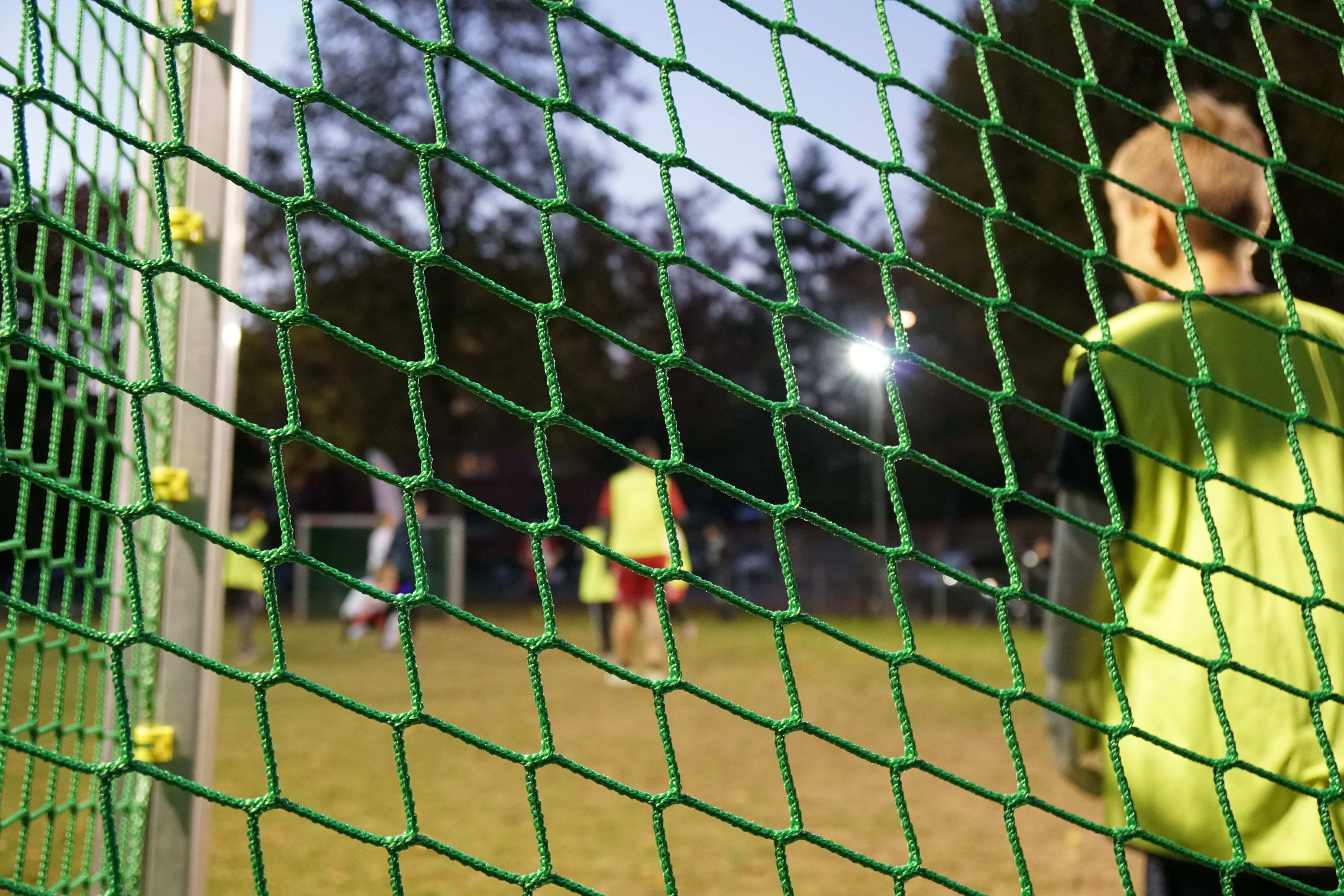 Ein Kind steht im Tor bei einem Fussballspiel.